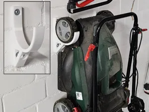 Wall mounting for lawn mowers or scarifiers