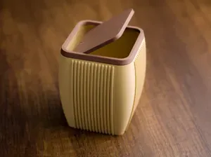 Desktop ribbed trash bin with lid.