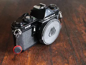 Pentax K body cap with/without the old Asahi Optical Co logotype.