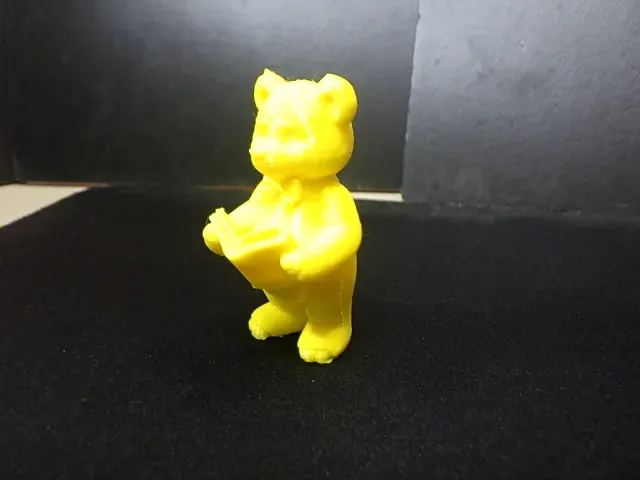 A cute teddy bear(Fitzgerald) standing, reading a book.